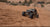 Off-road vehicle driving on a sandy desert landscape